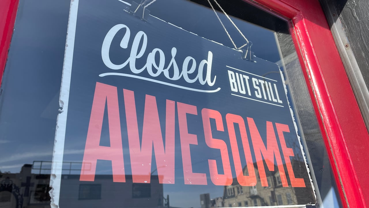 A closed sign in a business window that says "closed but still awesome."